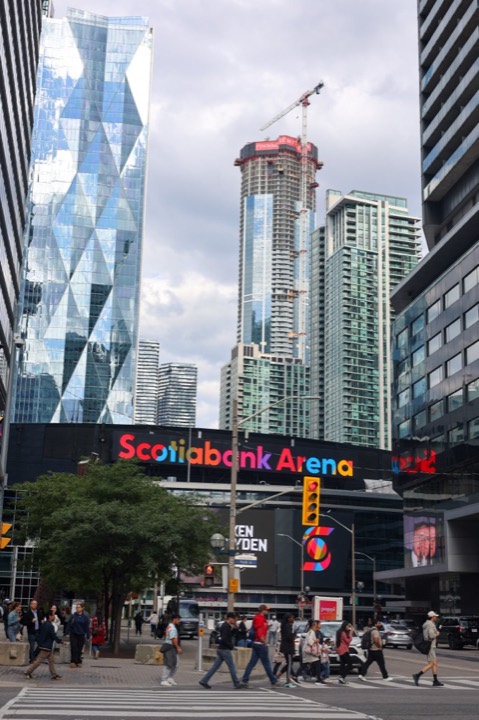 Downtown Toronto street scene with Scotiabank Arena signage and skyscrapers under construction